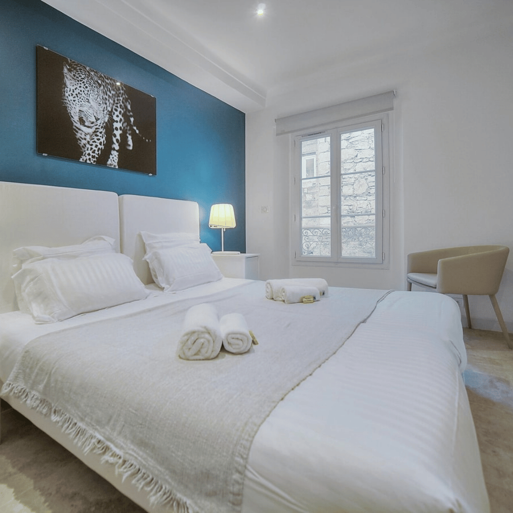 Intérieur de logement Airbnb, lit fait, serviettes roulées et posées, petite attention à l'arrivée